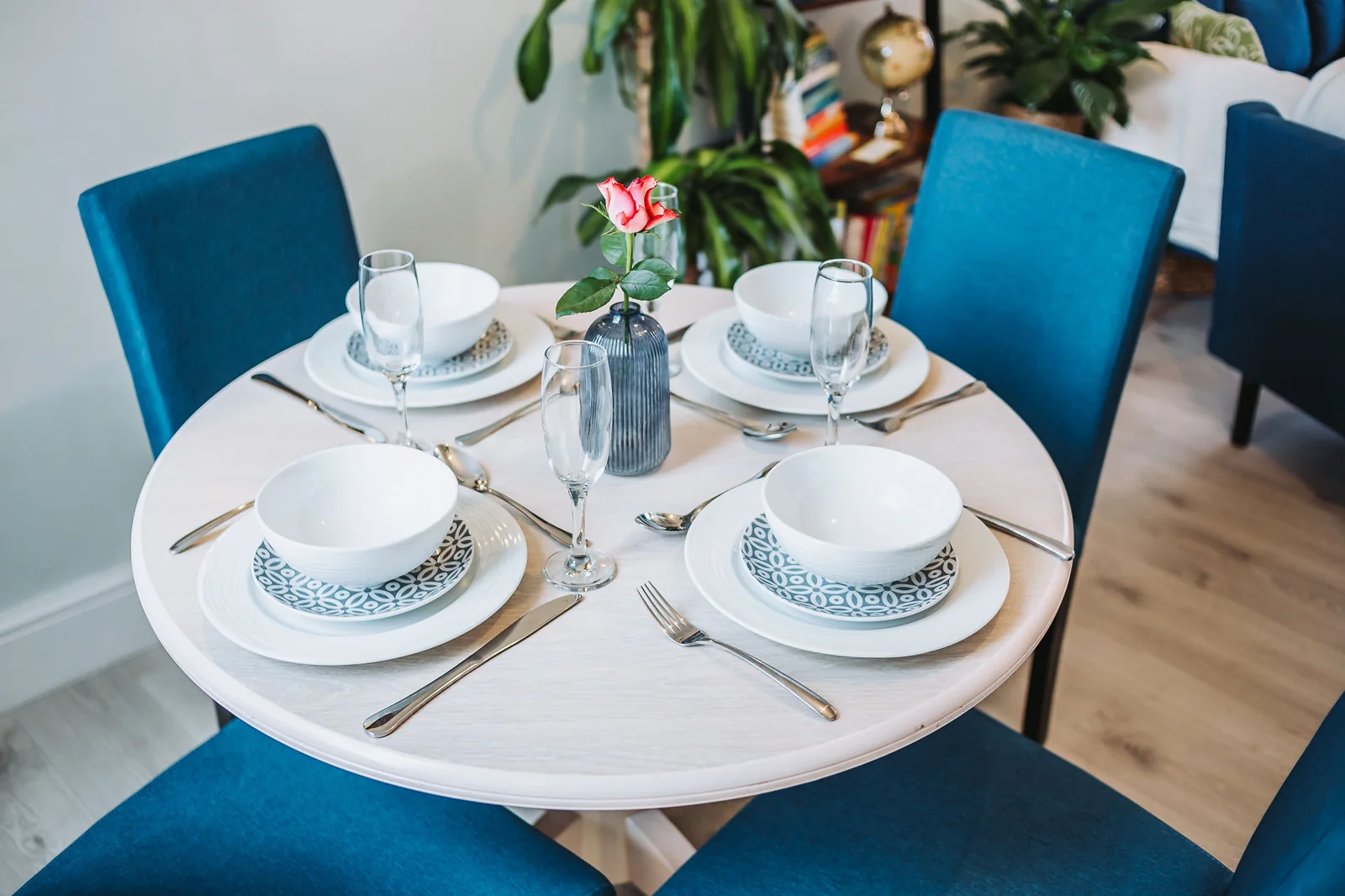 Dining table set for four with blue chairs